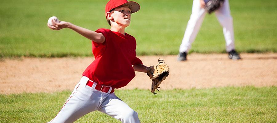 Little League baseball player pitching at game