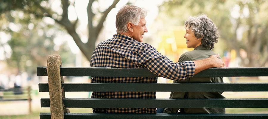 Happy senior couple relaxing on a park bench
