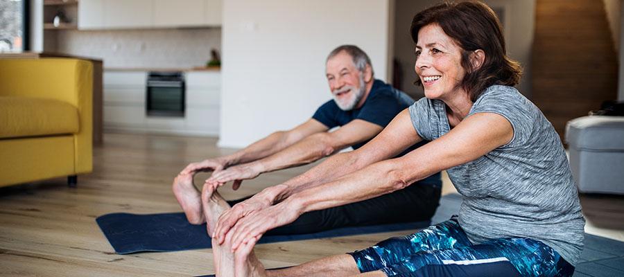 Couple stretching in their living room together