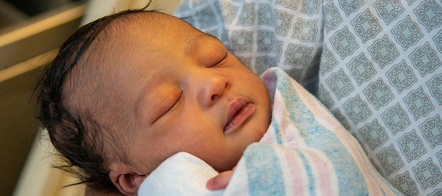 Mother holding her baby in delivery room