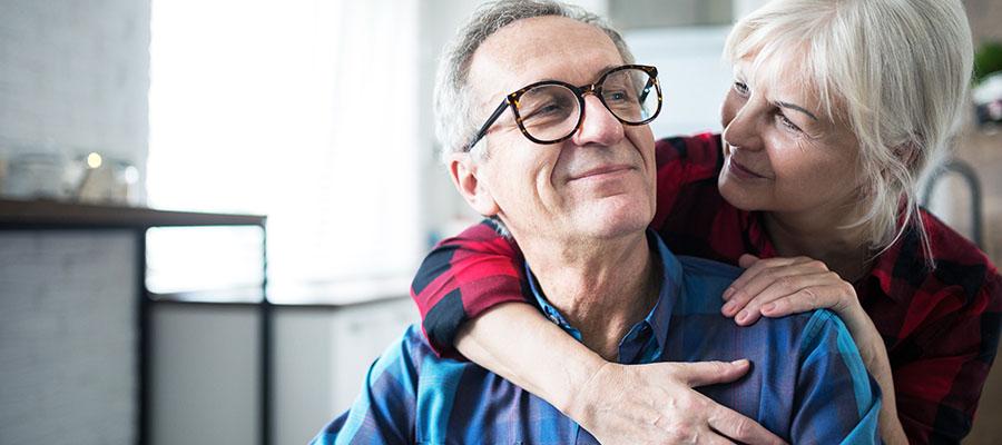 Senior woman embracing her husband