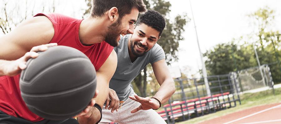 Two men playing basketball outside on court