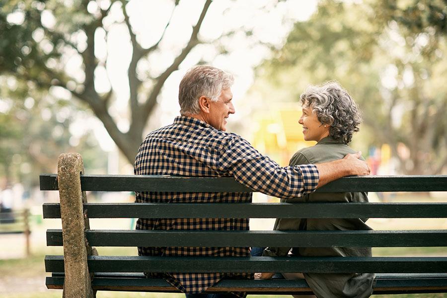 Happy senior couple relaxing on a park bench