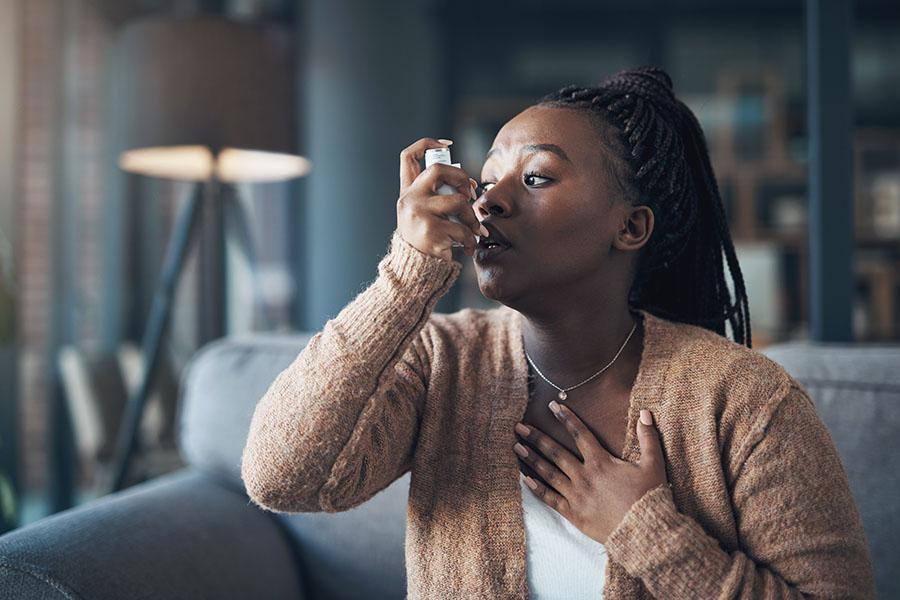 Woman using inhaler for her asthma