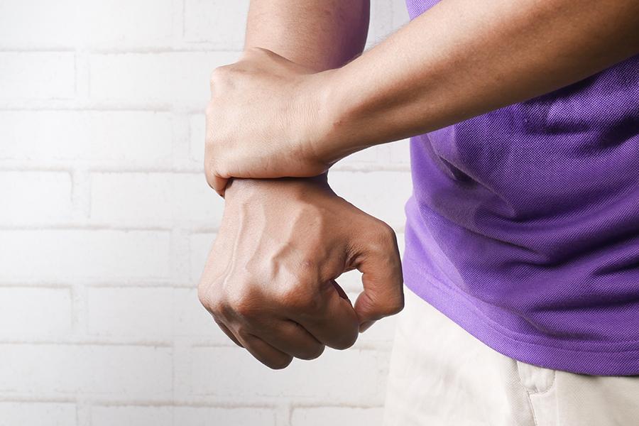 Man holding his wrist in pain due to suffering from carpal tunnel syndrome