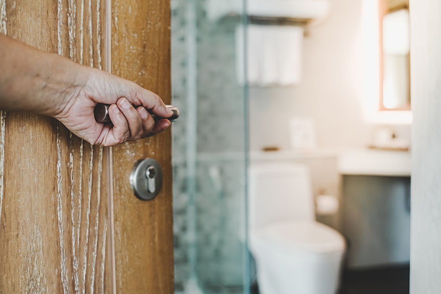 Man's hand opening bathroom door