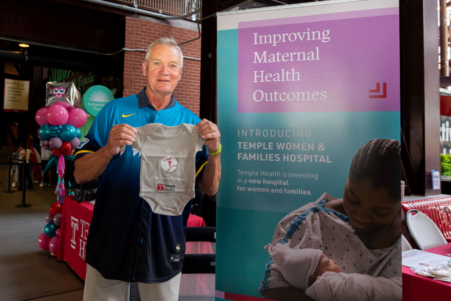 Dickie Noles with one of our Phillies-branded onesies, which all babies born at Temple hospitals will now receive.