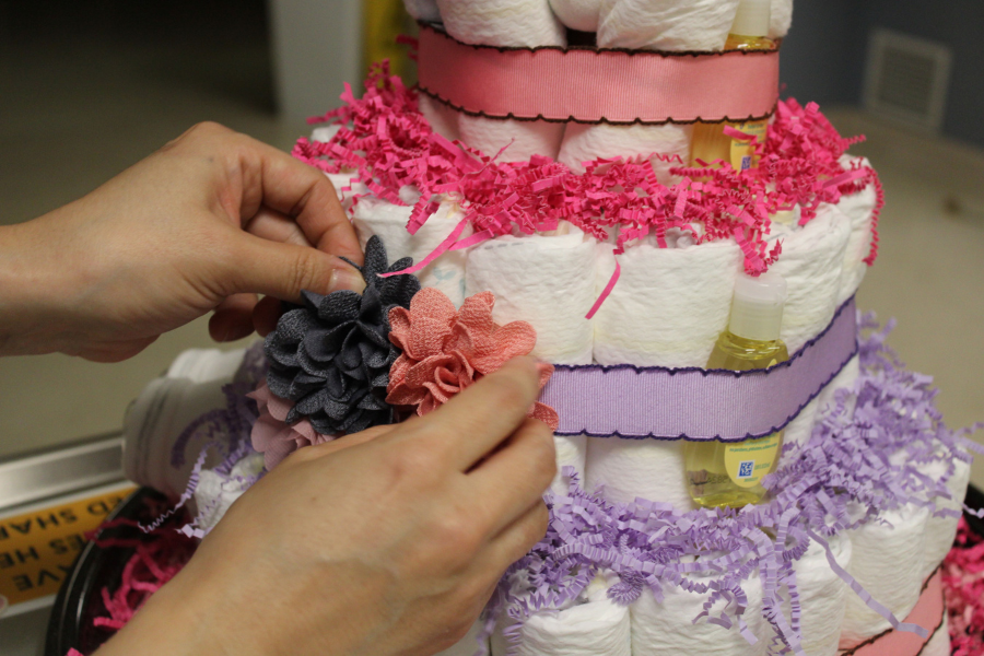 Baek applies three clip-on flower hair accessories as diaper cake decorations.