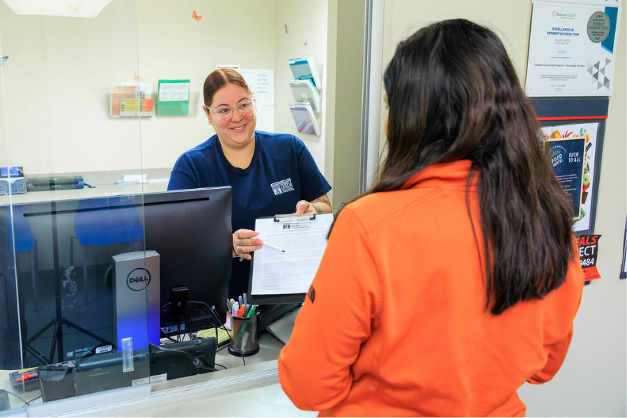 Front Desk Coordinator Brenda Fortin explains a form to a Wound Care Center patient.
