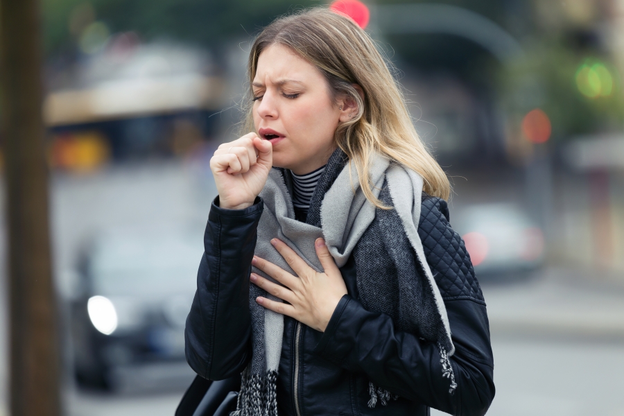 Woman coughing in the street