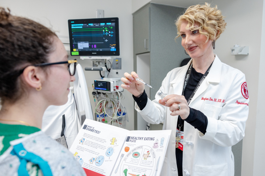 Meaghan Kim helps a patient understand proper injection technique.