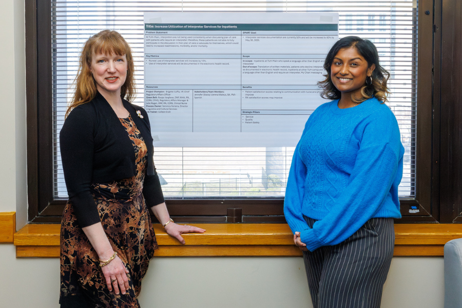Julie Rogan and Roopa Varghese with their poster on their project, "Increase Utilization of Interpreter Services for Inpatients.