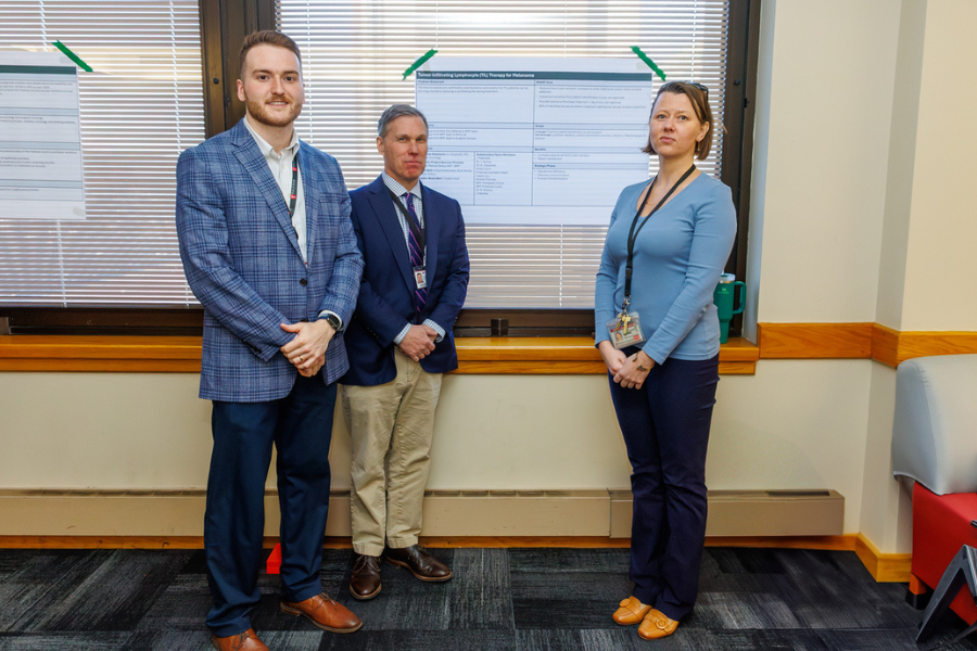 Brian Burke, Jordan Sellers, and Yuliya Shestovska with their poster on their project, "Tumor Infiltrating Lymphocyte Therapy Workflow Optimization.