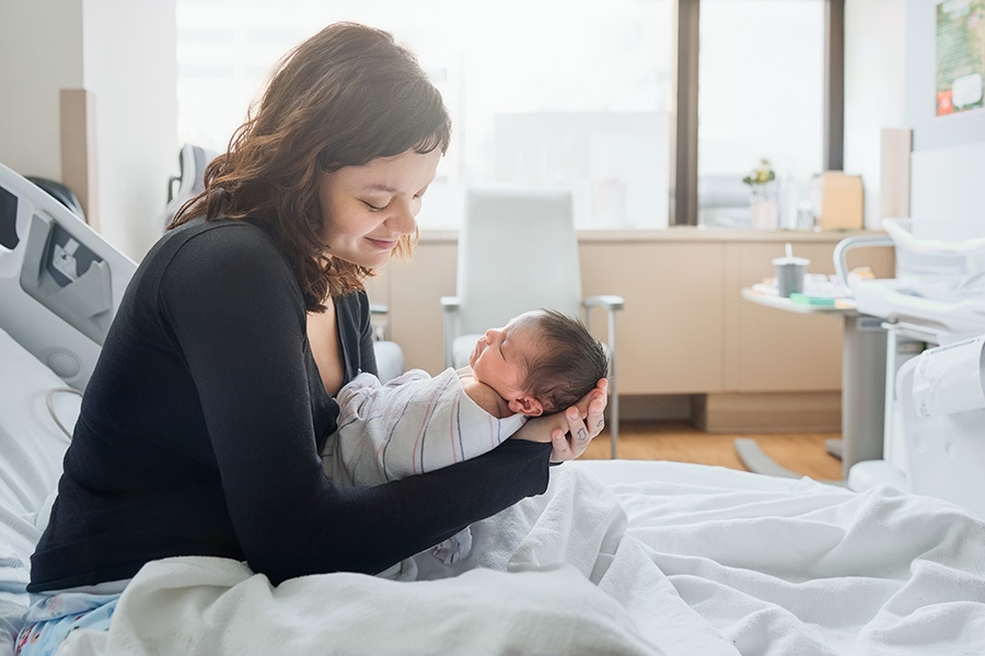New mother holding, looking at baby