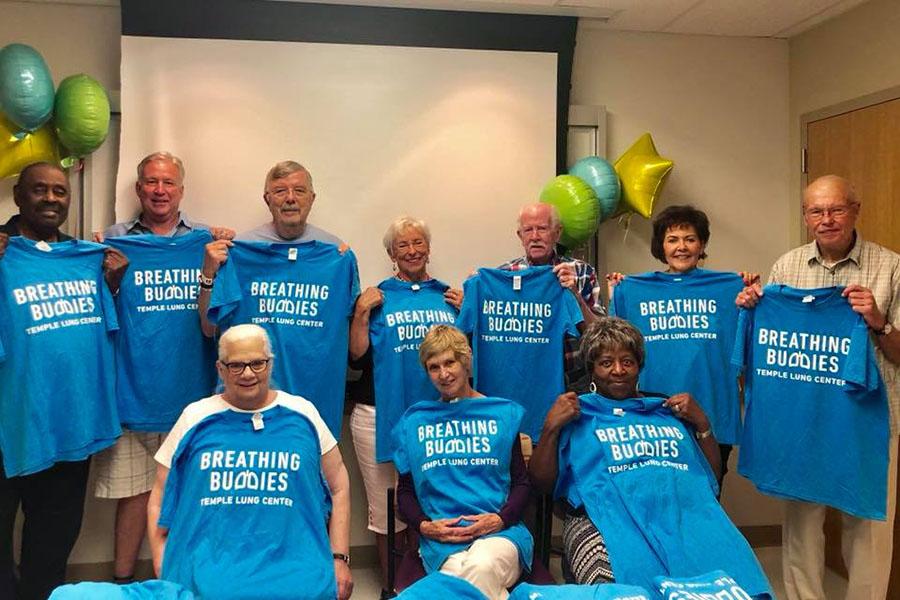 Breathing buddies group holding T-shirts