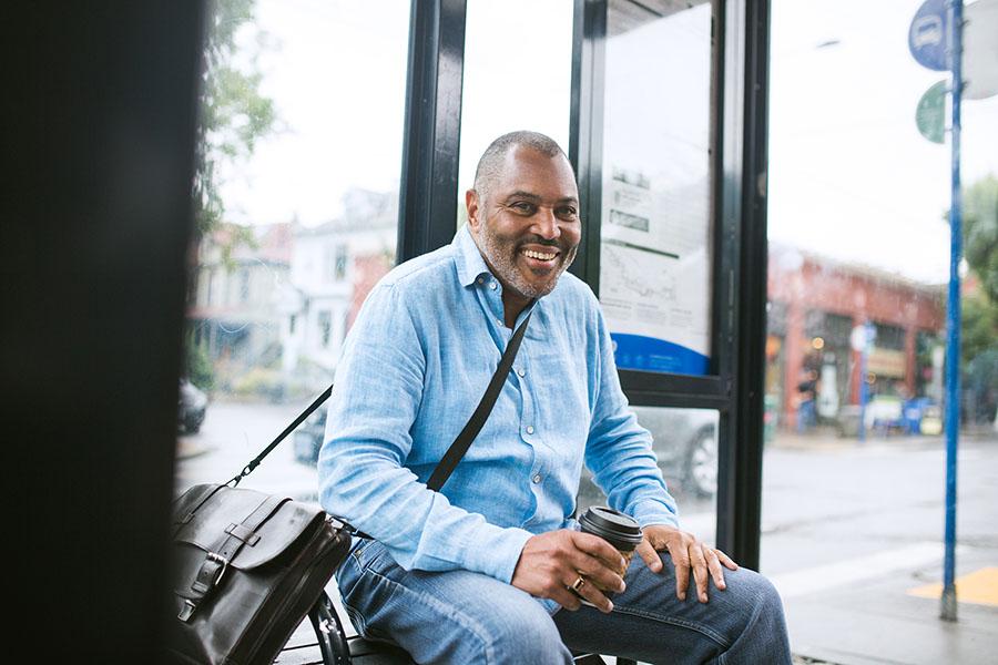Man smiling waiting for bus