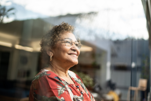 Older woman smiling, looking out window