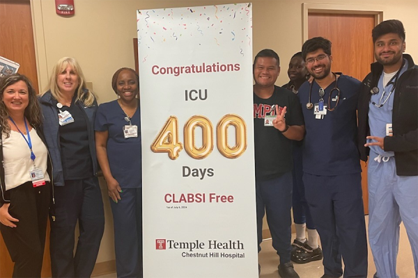 The ICU staff poses with their banner congratulating them for 400 days CLABSI-free.