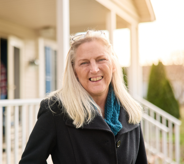 Donna smiling outside her house