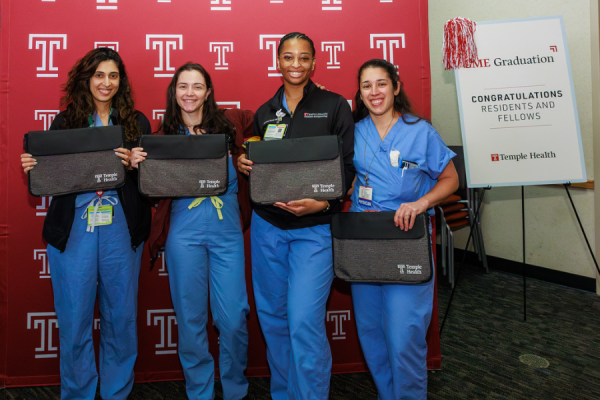 Graduates with their complimentary Temple Health laptop sleeves: a gift from the Office of Graduate Medical Education.