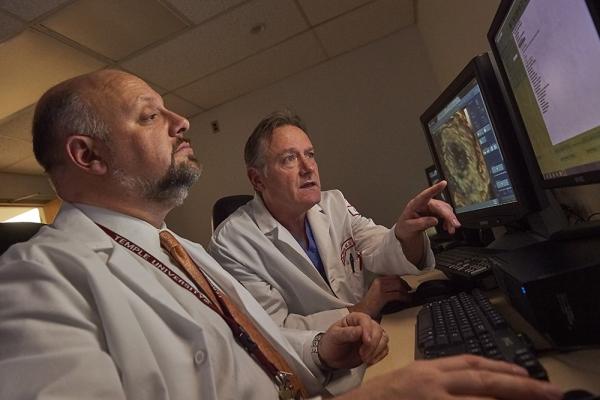 Brian O'Murchu and Martin G. Keane examining screen