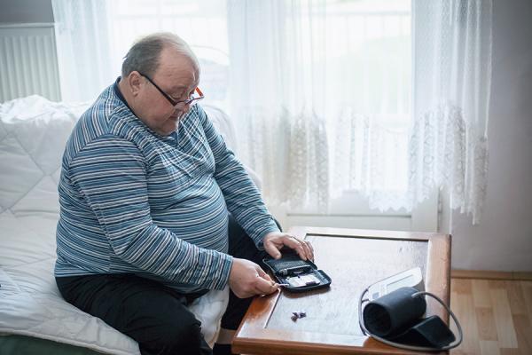 Older man checking blood sugar levels